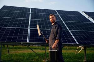 Keep, it clean. Man is working with solar panels outdoors at daytime photo