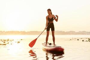 Having ,a ,great time by swimming. Young woman is with the sup board on the lake photo