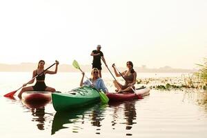 Women and man. Friends, are together on sup boards on the lake photo