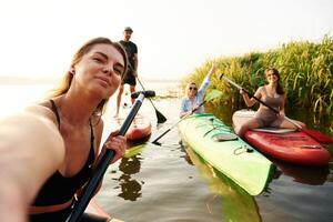 Taking ,selfie. Friends are together on sup boards on the lake photo
