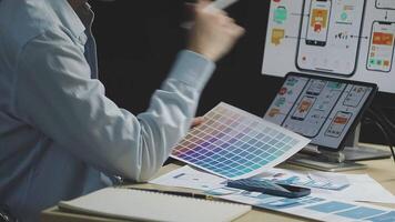 A man is working on a computer with a color palette video