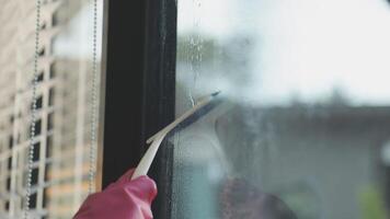 A person in rubber gloves cleaning a window video