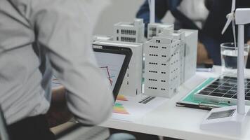 Business people working on a project with a model of a building video