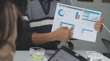 A man and woman are looking at a chart on a paper video