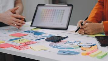 Two people working on a project with a tablet and sticky notes video