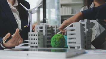 Business people working on a project with model buildings video