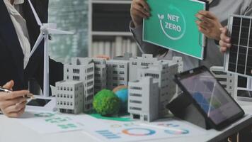 A group of people working on a project with a sign that says net zero video