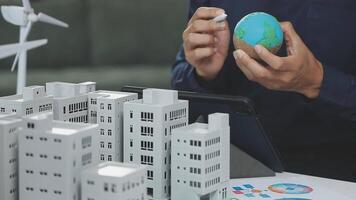 Man holding a model of a city and a globe video