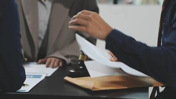 Two people sitting at a table with papers video