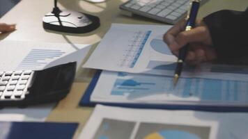 A business person is working on a spreadsheet with a calculator video