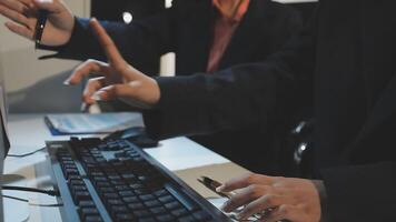 Two people are using a computer keyboard and mouse video