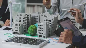 A group of people are working on a model of a building video