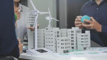 A group of people standing around a table with wind turbines video