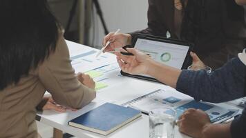 Three people sitting at a table with a tablet and pen video