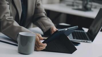 A person using a tablet on a desk with a cup of coffee video