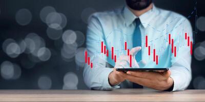 Man using smartphone with stock chart photo