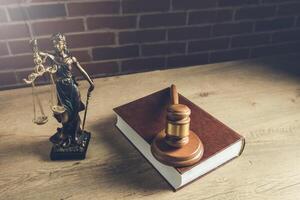 Lawyer statue and book on wooden table photo