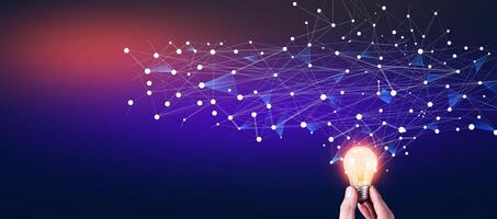 Hand holding light bulb with connected dots and network connection on dark background photo
