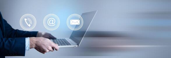 A man in a suit is using a laptop with email icons photo