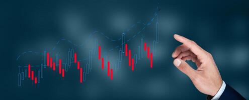 Hand pointing to a chart of a stock market graph photo