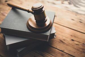 Judge gavel on books on wooden table photo