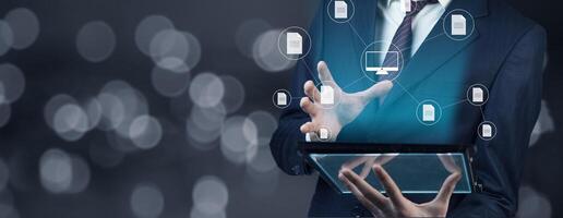 Businessman using tablet with icons on background photo