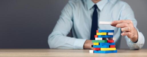 A man in a tie is holding a stack of blocks photo