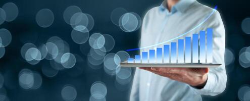 Businessman holding tablet with graph on it photo