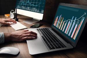 A person is using a laptop computer with graphs on it photo