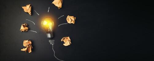 A light bulb surrounded by paper and crumpled up pieces photo