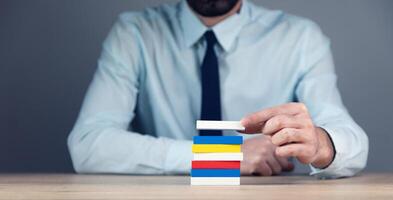 A man in a shirt and tie is holding a stack of colored cards photo