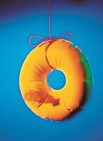 a donut hanging from a string with a red ribbon photo