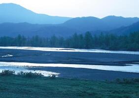 a river with a mountain in the background. photo