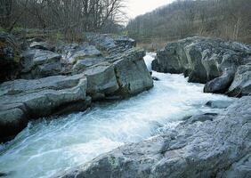 a river flowing through a rocky area photo