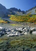 a mountain range with a lake and colorful trees photo