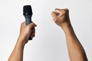 Person speaking into microphone with raised fist gesture photo