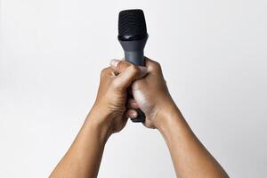 Close up of hands holding microphone on white background photo