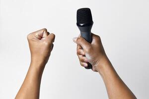 Individual with microphone and clenched fist gesture isolated on white photo