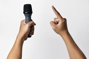 Confident Asian man with microphone pointing up on white background photo