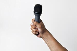 Speaker holding microphone from underneath angle on white background photo