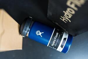 Bangkok, Thailand - May 28, 2025 Hydro Flask water bottle, indigo color wide mouth flex sip lid 16 oz placed with package. photo