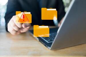 Hand touch a virtual folder with alert symbol. Cyberattacks on computer networks. photo