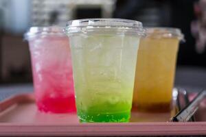 Refreshing green soda served with ice in a clear glass and two refreshing drink background photo