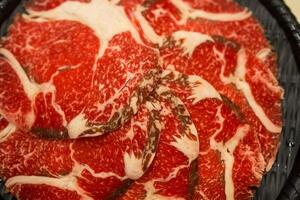 Raw beef neatly arranged in a black container photo