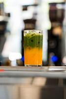 Iced matcha latte separated layers, matcha green tea with fresh orange juice photo