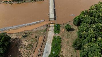 Aerial view of a broken bridge in Doi Hang subdistrict after Typhoon Yagi has swept and river flooded in Chiang Rai province of Thailand. photo