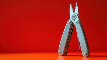 Multi-Functional Silver Tool on Vibrant Red Background for DIY and Outdoor Projects photo