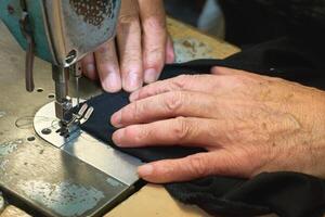 Sewing machine and working hands of a tailor photo