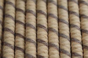 Brown and beige twisted rope rolls lined up in a neat arrangement on a flat surface in a well-lit space photo