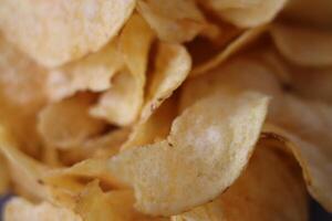 Crispy potato chips served in a close-up view showcasing texture and golden color on a casual snack table photo